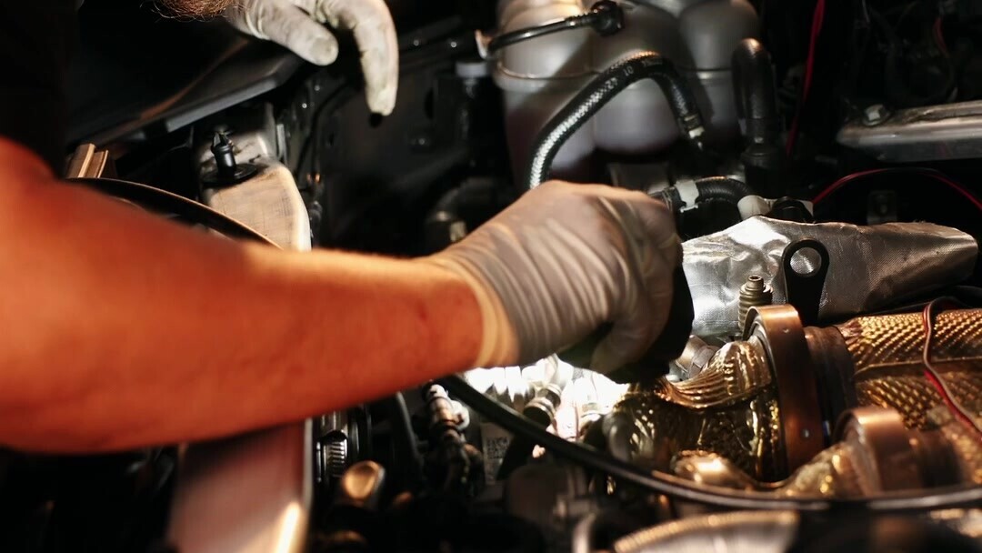 Un mecánico de Service99 trabajando bajo el capó de un auto en el taller.